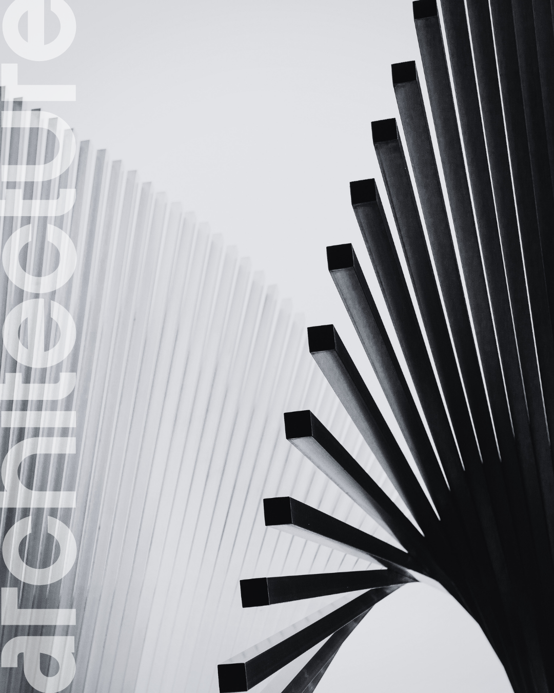 Close-up of a modern architectural sculpture with black elongated rectangular elements extending outward from a central point against a cloudy sky.