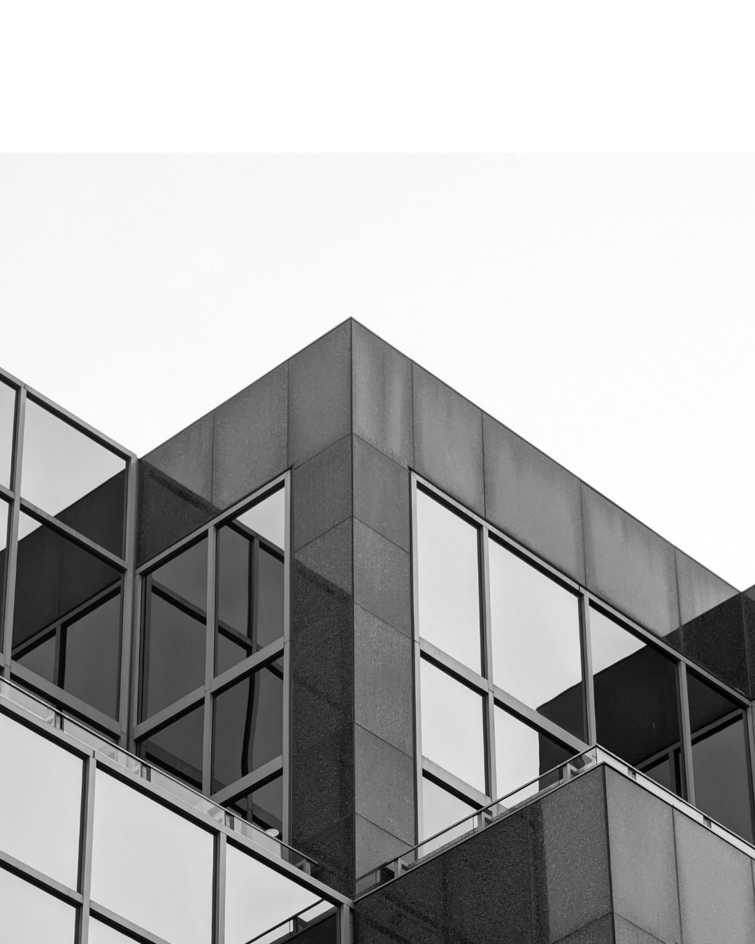 Close-up of a modern building with large glass windows and geometric lines in black and white