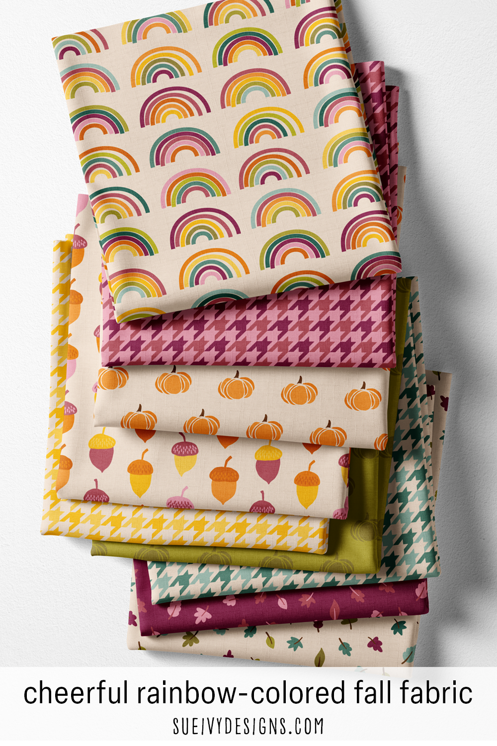 Autumn Rainbows fabric in nine cuts — rainbow arcs, houndstooth, pumpkins, acorns and leaves, mostly on warm cream with green and plum tonals.