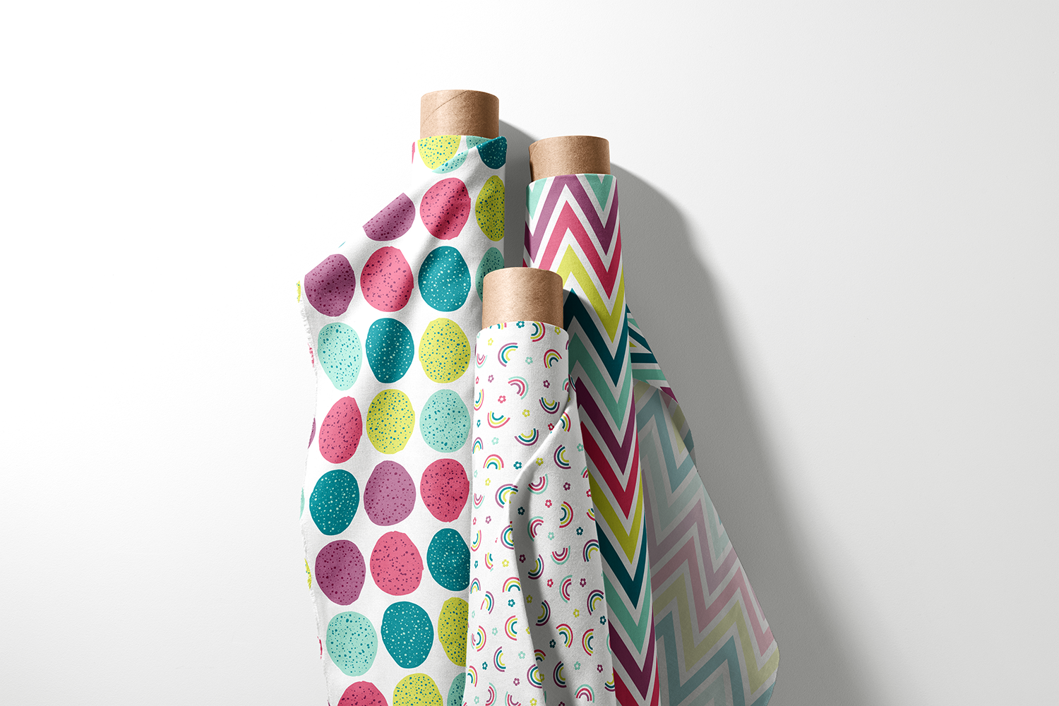 Three rolls of speckled Easter egg, rainbow, and chevron fabric from the Easter Rainbows collection by Sue Ivy Designs
