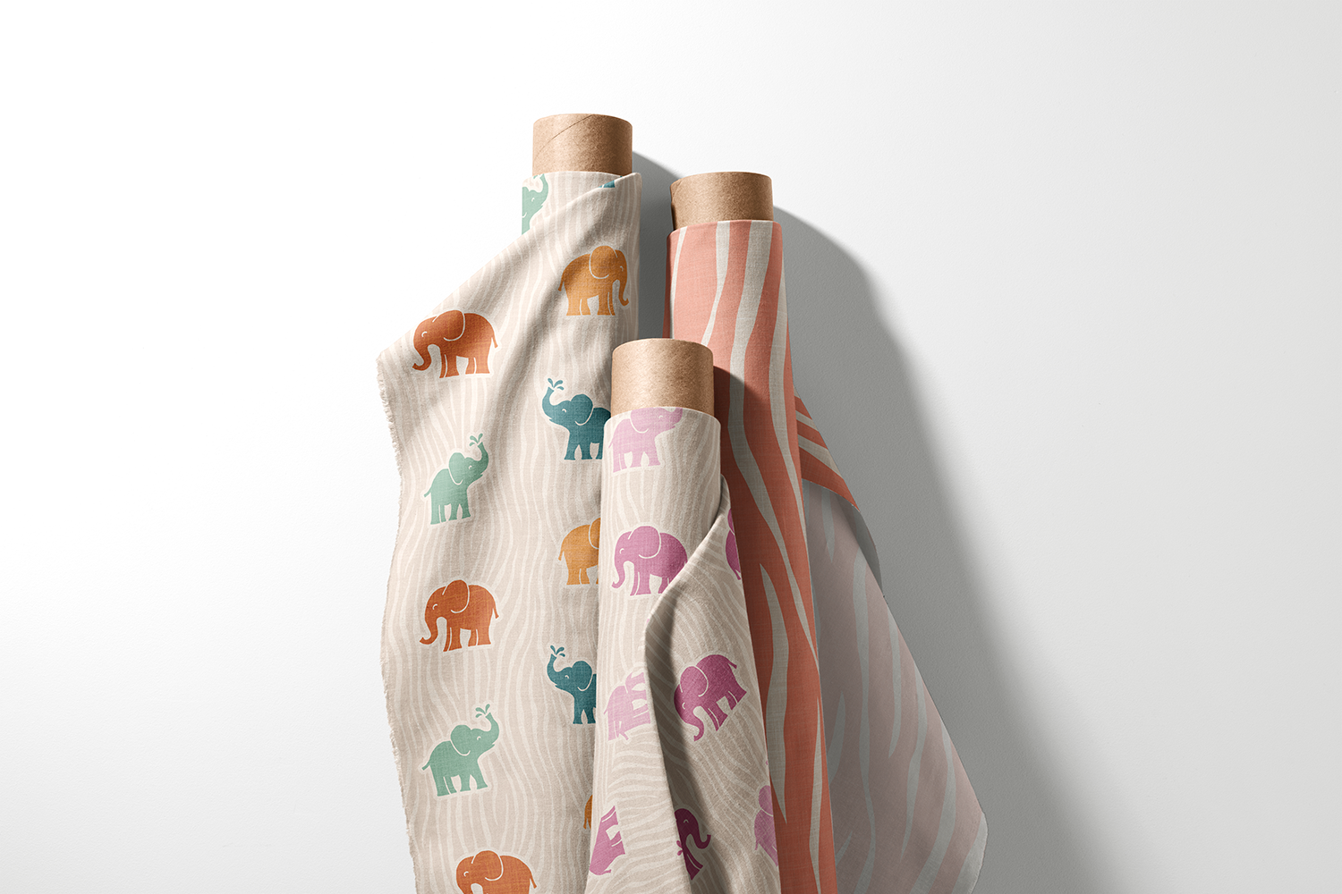 Three rolls of colorful elephant and zebra stripe fabric from the Boho Safari Nursery collection by Sue Ivy Designs