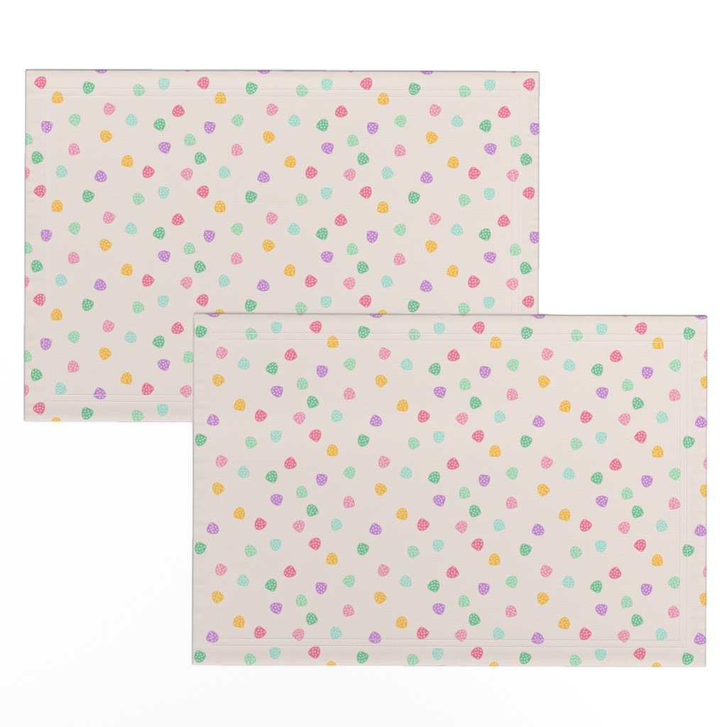 Placemats in scattered bright pastel gumdrop candies on cream.