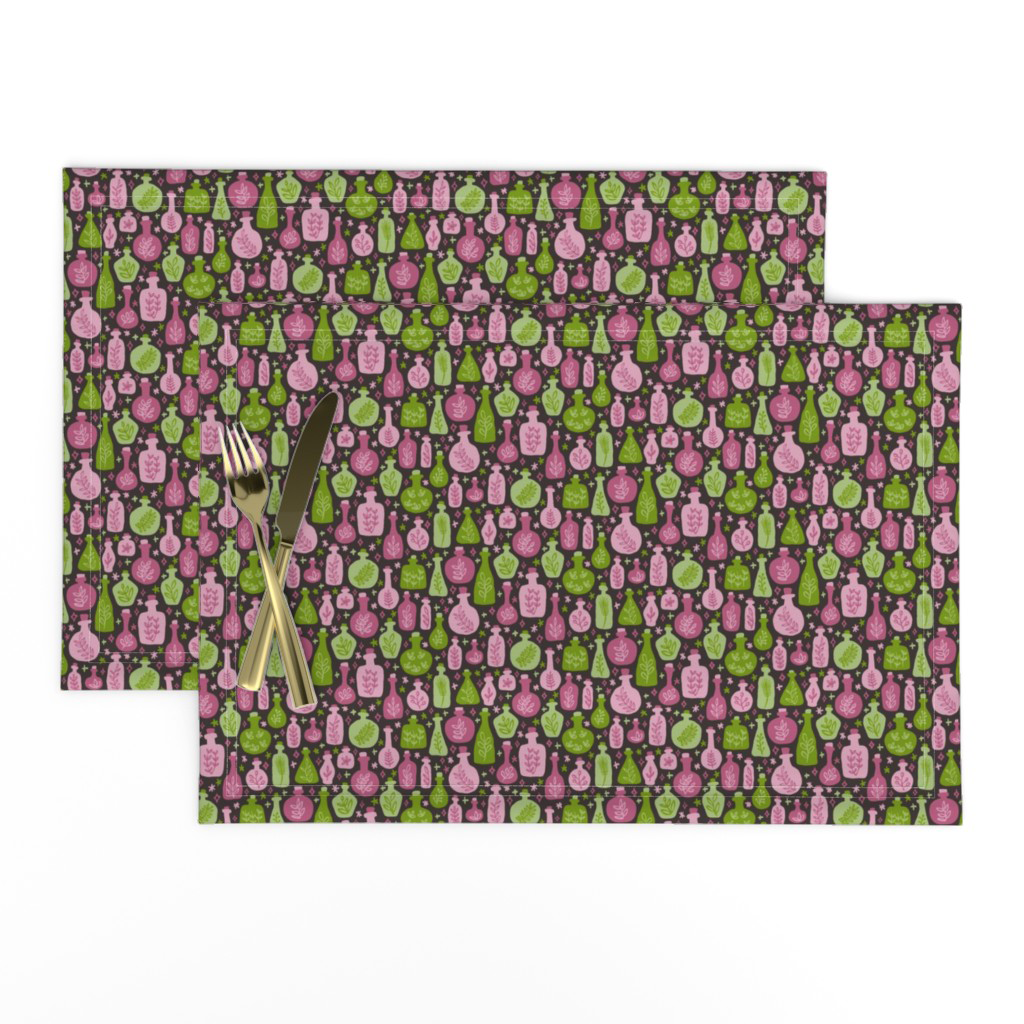 Placemats in the potion bottle print, green and raspberry purple bottles with magic bits on black.