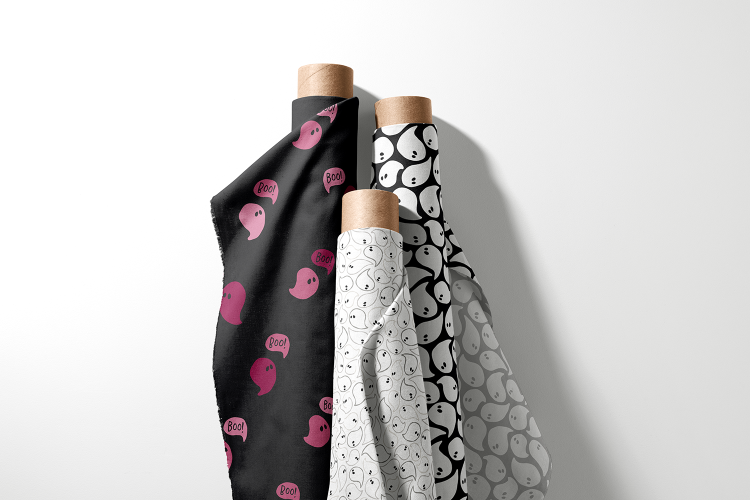 Three rolls of ghost print fabric in purple, black, and white from the Happy Haunting collection by Sue Ivy Designs