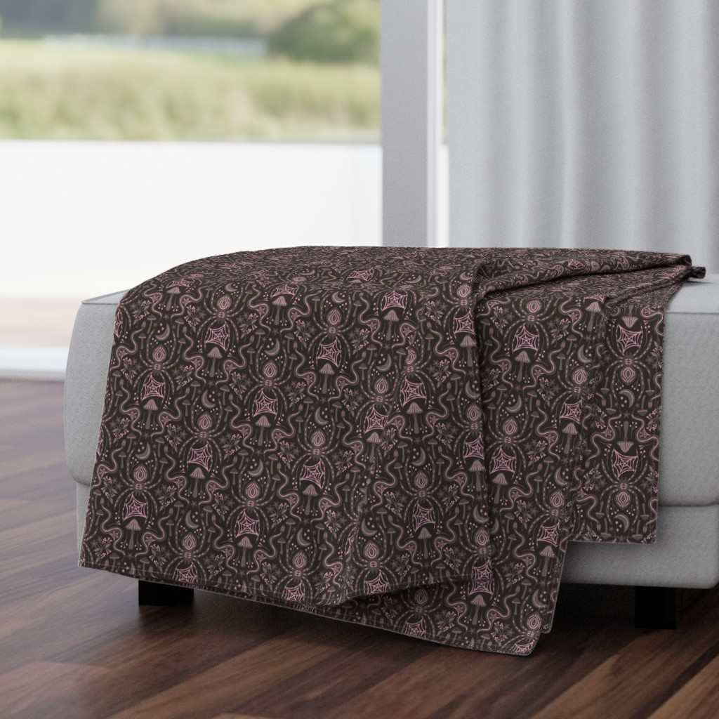 Throw blanket in the large spider and snake damask, warm gray with pale raspberry purple pops on black.