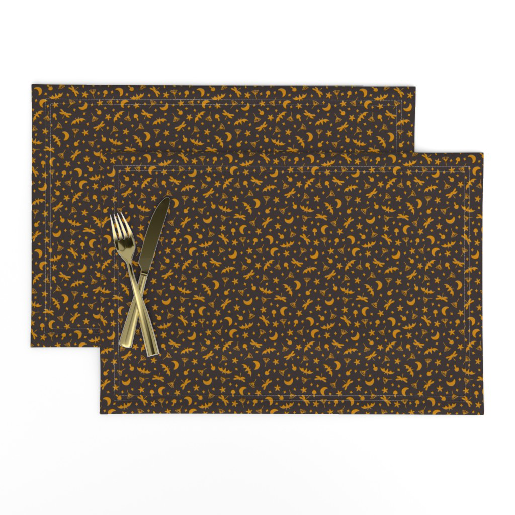 Halloween botanical ditsy placemats in gold on black, set for a moody Halloween dinner table.