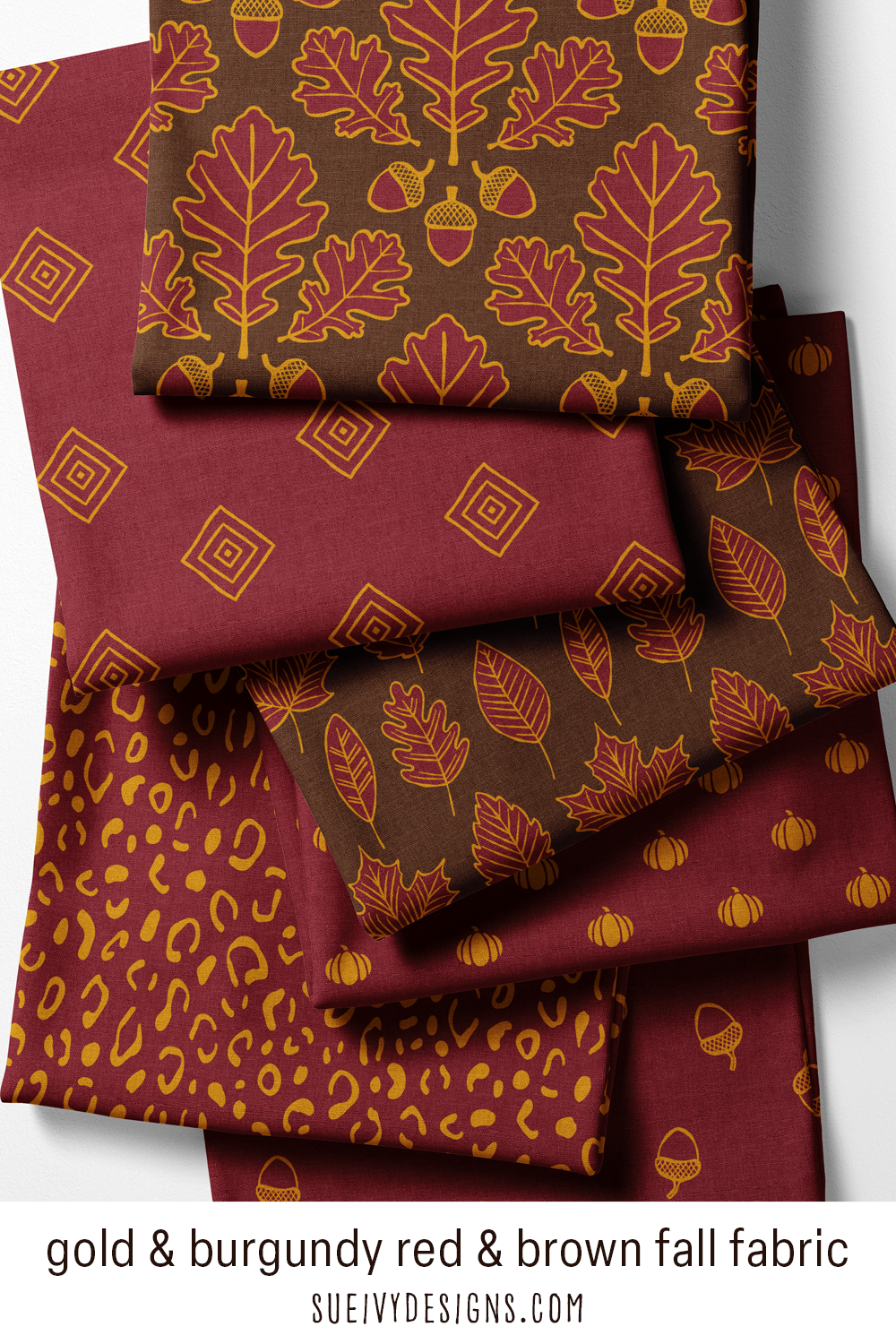 All six Gilded Autumn fabric prints in one fan — acorns, oak leaves, pumpkins, leopard spots and diamonds in gold on burgundy and dark brown.