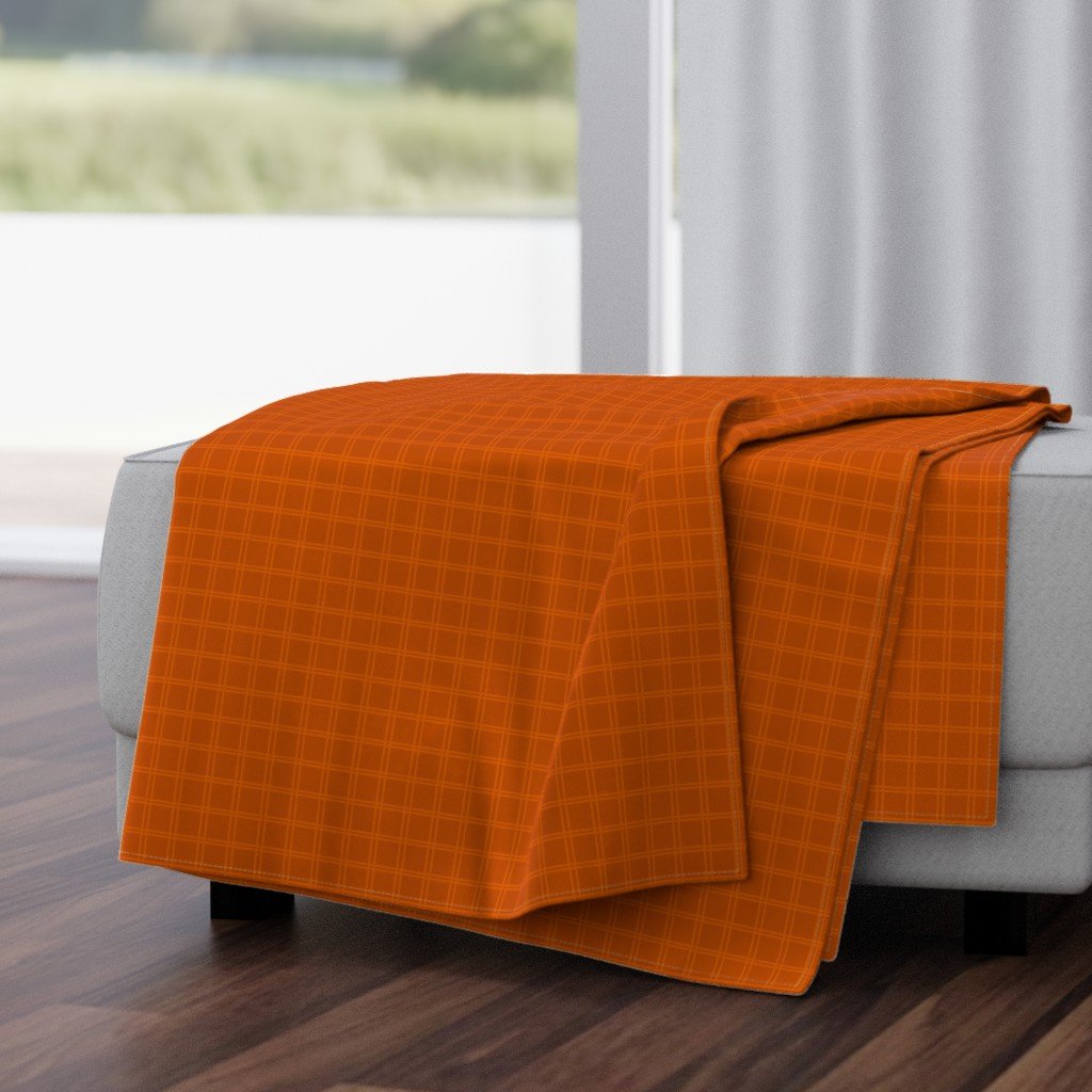 Rust orange trellis plaid throw blanket, a cozy plaid look for warming up on the couch all autumn.