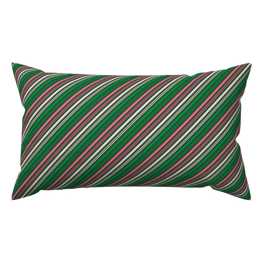 Lumbar throw pillow in pink, green & cream diagonal candy-cane stripes on dark green.