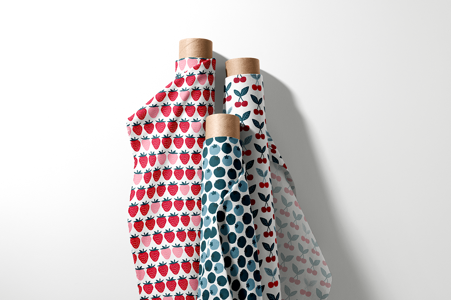 Three rolls of strawberry, blueberry, and cherry fabric from the Americana Picnic collection by Sue Ivy Designs