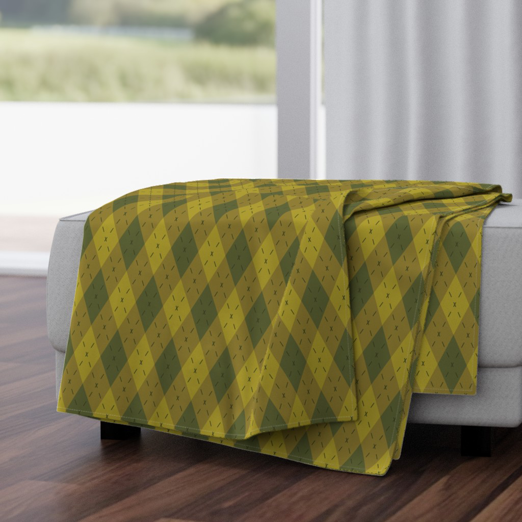 Throw blanket in olive and moss argyle — elongated dashes and sharp diamonds, a modern take on a cozy classic.