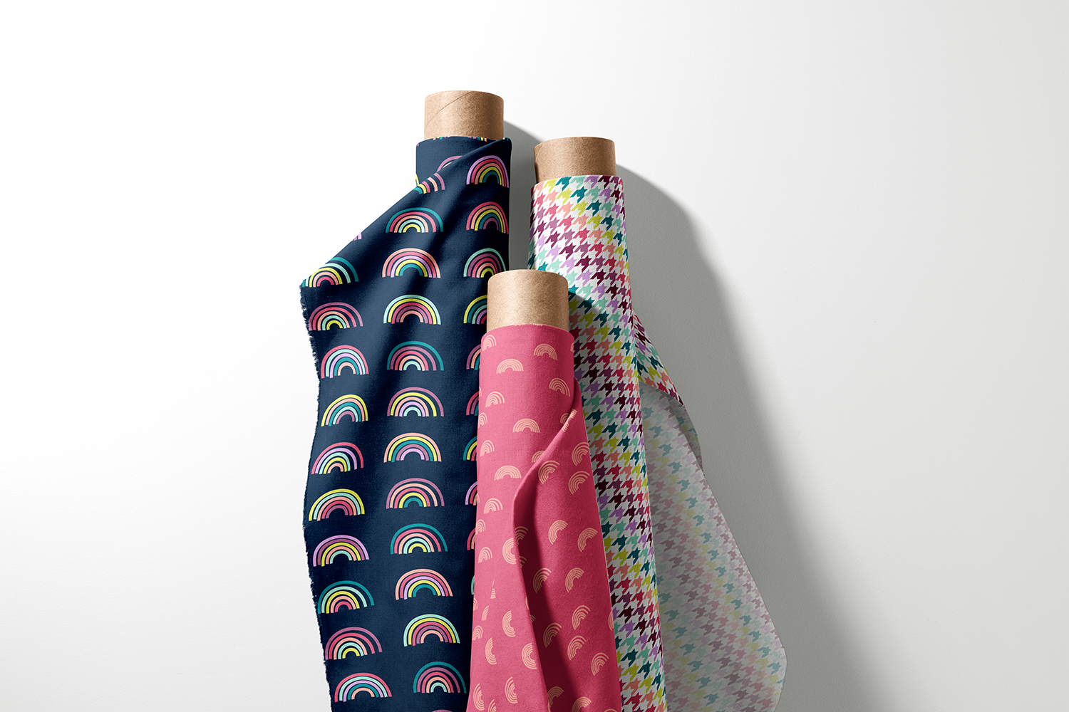 Three rolls of rainbow, mini rainbow, and houndstooth fabric from the Everyday Rainbows collection by Sue Ivy Designs