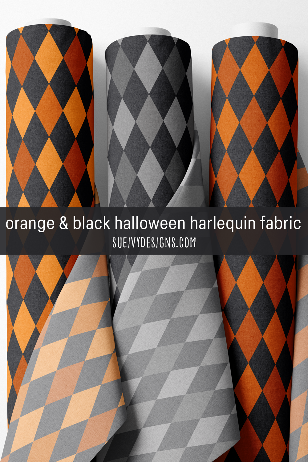 Three rolls of large harlequin fabric in bright orange and black, gray and black, and dark orange and black, for Halloween projects.