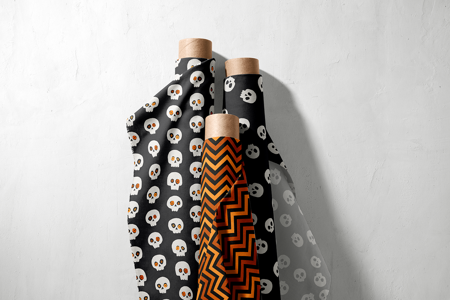 Three rolls of skull print and orange chevron fabric from the Spooktacular collection by Sue Ivy Designs