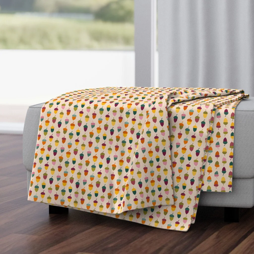 Throw blanket in the Autumn Rainbows acorn print by Sue Ivy Designs — colorful hand-drawn acorns in rainbow tones, on Spoonflower home decor.