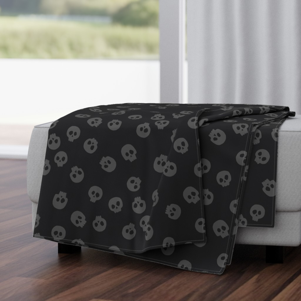 Charcoal gray skulls on black Halloween throw blanket sewn from extra-large tossed skulls fabric