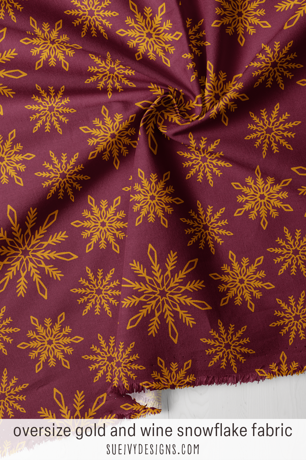 Wine-red snowflakes at oversize scale, gold drifting on a deep ground — for a cozy winter throw.