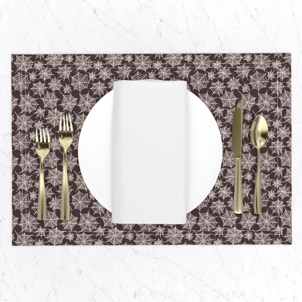 Halloween spiderweb placemat in warm black, a subtly spooky table setting for fall and Halloween dinners.