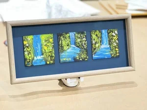 Three small landscape paintings of waterfalls displayed in a row within a light-colored frame. custom framing brookline pictureplacebrookline.com