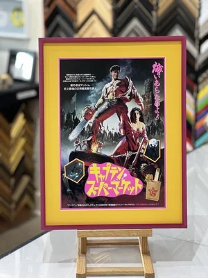 Vintage movie poster framed on a yellow and pink border, featuring a man and woman in a fantasy setting with Japanese text and graphics. from the Coolidge Corner Theater  custom framing brookline pictureplacebrookline.com