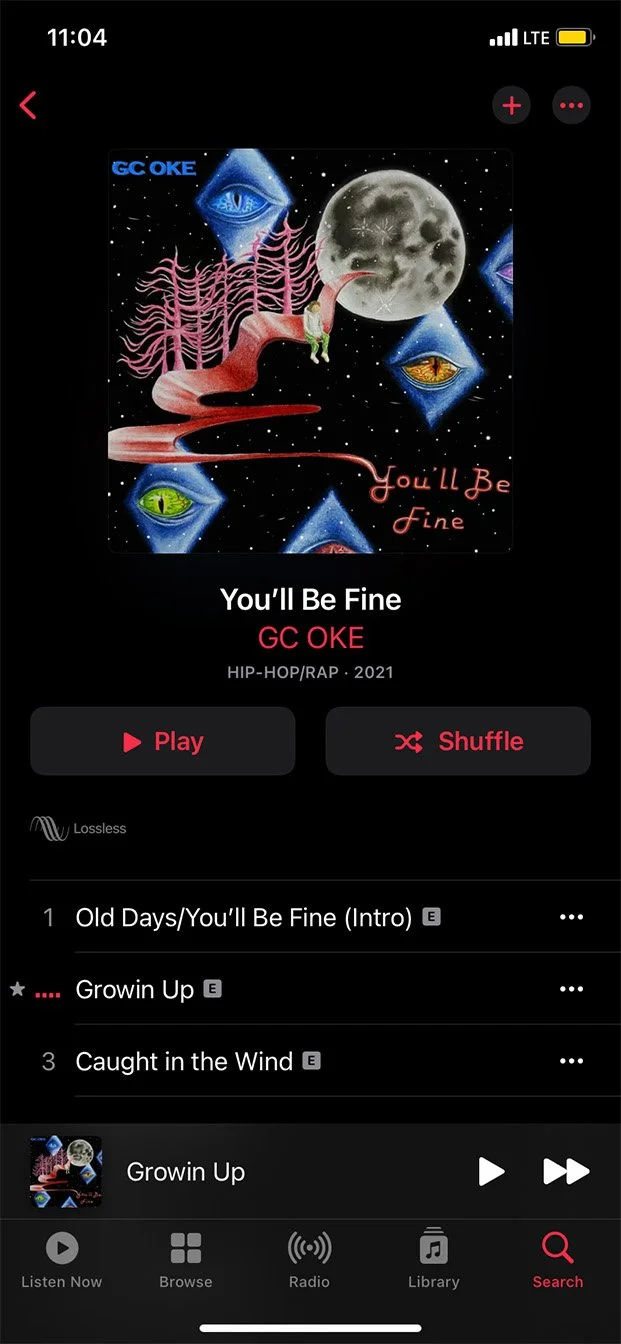 Music streaming app showing the album art for 'You'll Be Fine' by GC OKE, with a surreal, cosmic artwork featuring eyes, a moon, and a pink pathway, with song titles and playback controls.