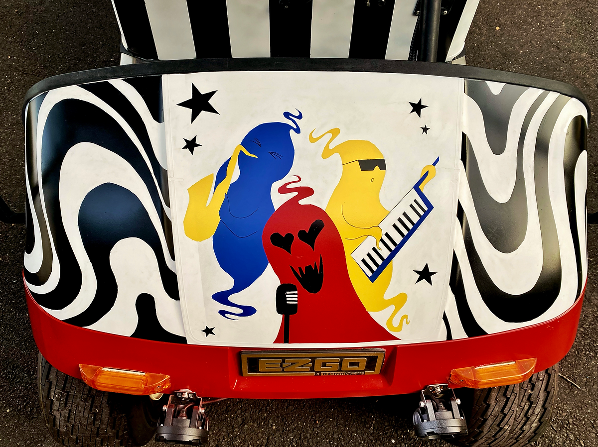 Colorful cartoon of three ghost-like characters singing and playing musical instruments, with a swirling black and white background and star accents.