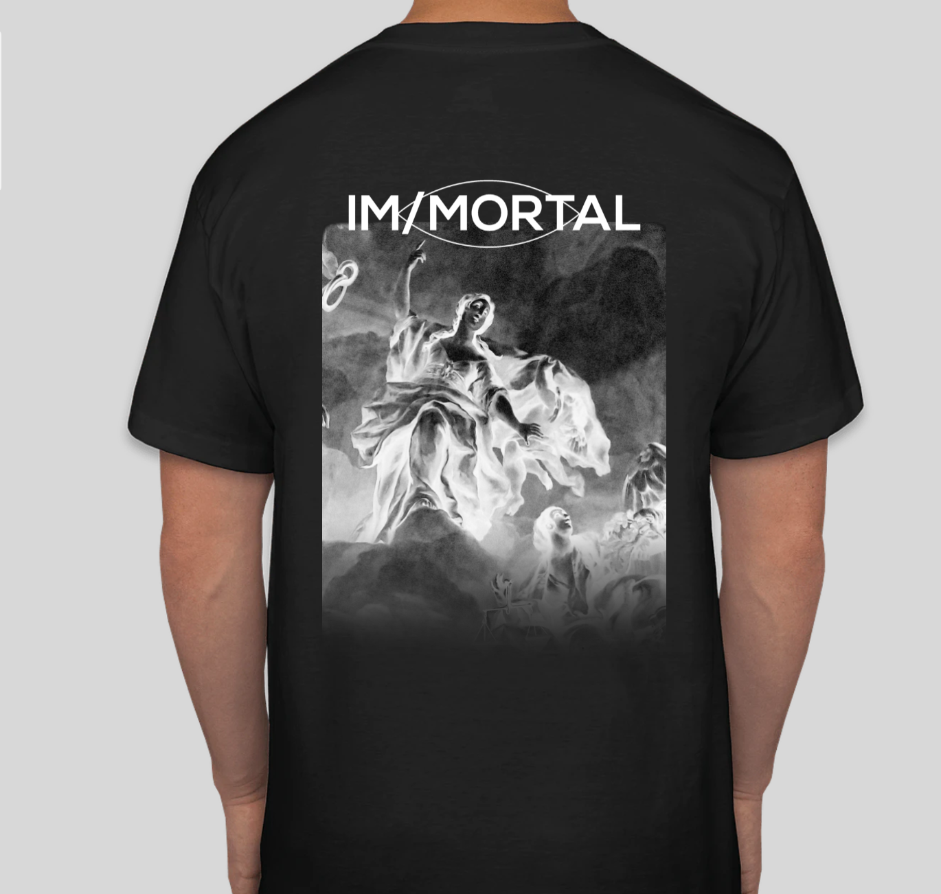 Back of a person wearing a black T-shirt with the word 'IM/MORTAL' and an artistic monochrome image of a woman in a flowing dress, surrounded by clouds and abstract figures.