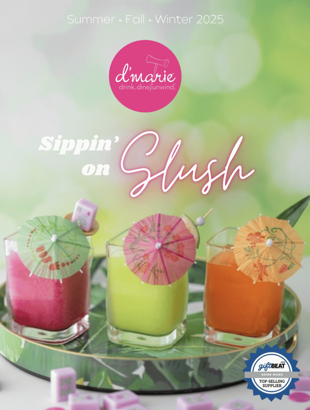 Colorful tropical drinks topped with miniature paper umbrellas on a decorative tray with a blurred green background. The text reads 'Summer + Fall + Winter 2025, Sippin' on Slush,' and the logo 'd'marie' with the tagline 'drink. dine. unwind.' appears at the top.