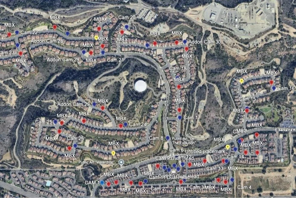 A satellite map of a residential area with houses, roads, and labeled camera points.