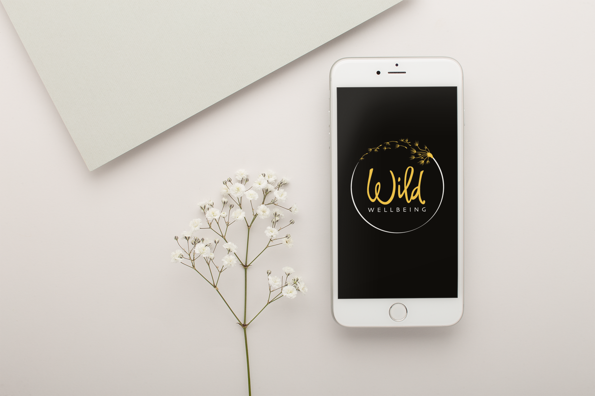 silver-iphone-mockup-lying-next-to-small-white-flowers-22019.png
