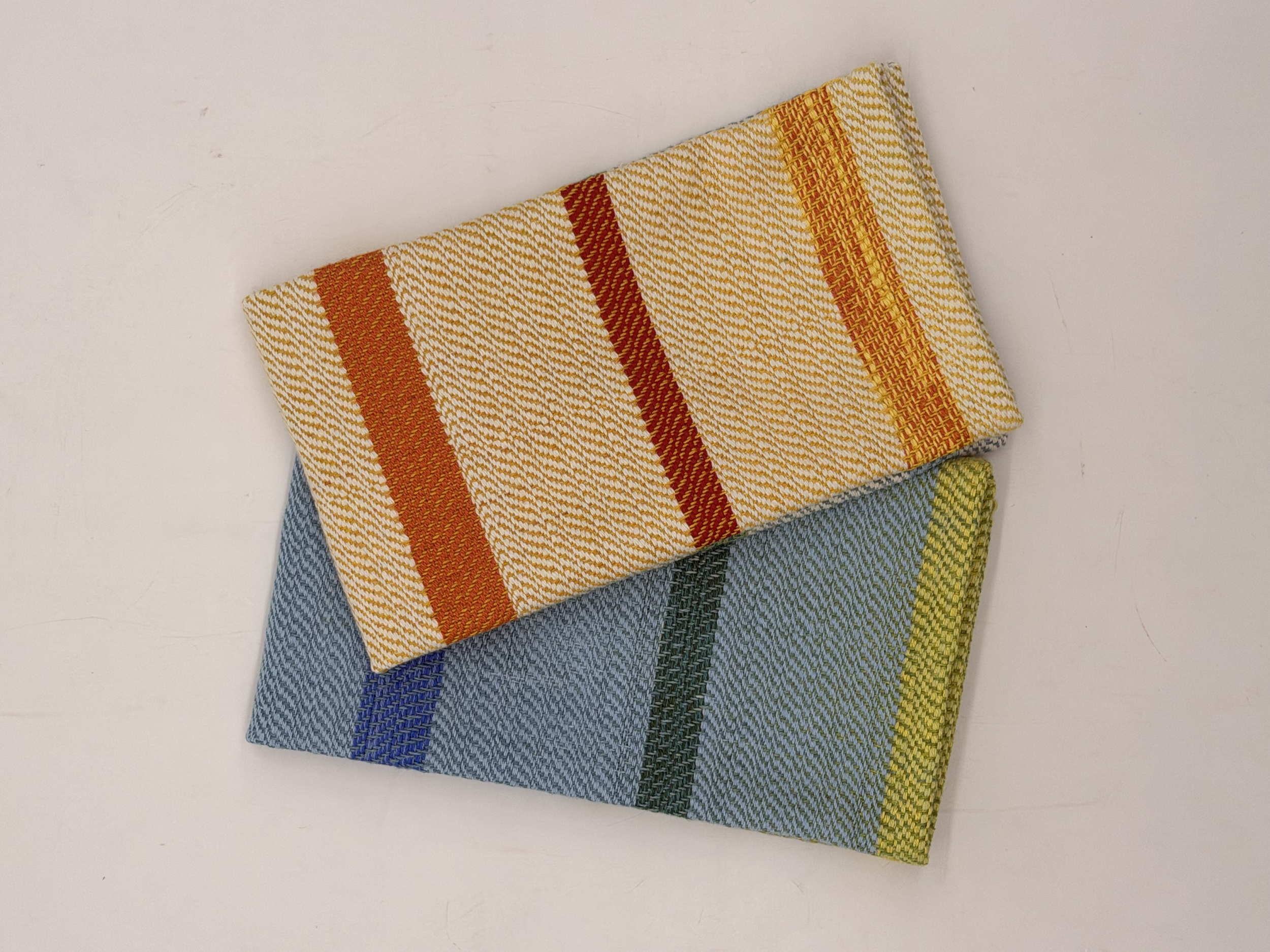Colorful striped fabric napkins folded on a white surface.