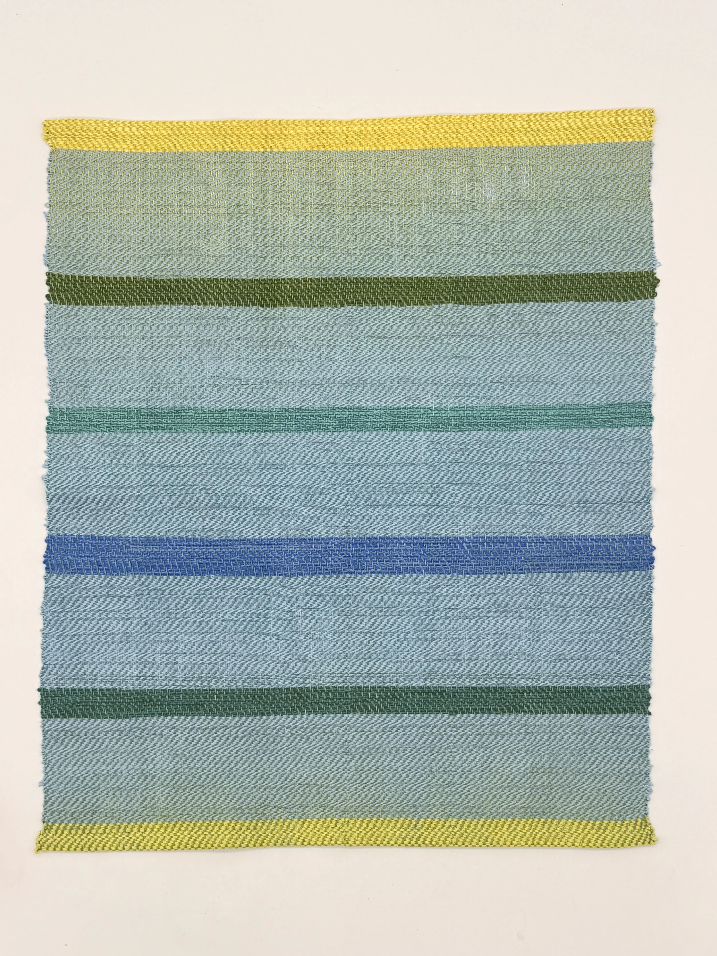 A fabric swatch with horizontal stripes in shades of yellow, green, blue, and teal.