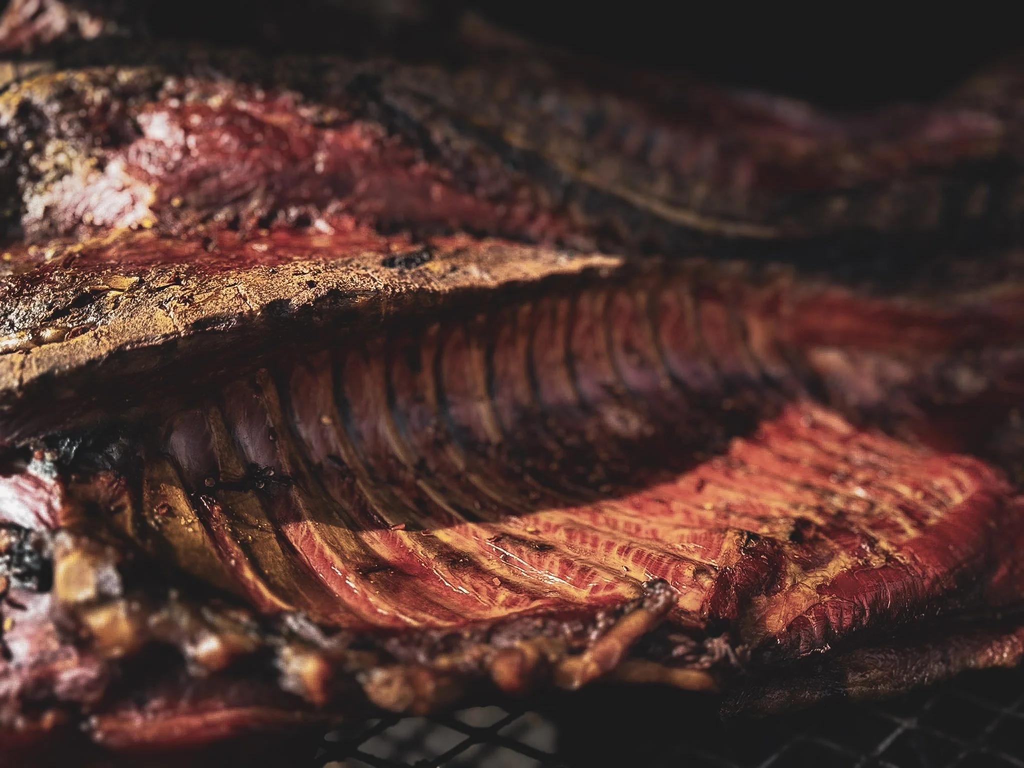 Close-up of a grilled or cooked piece of meat, showing charred and well-cooked surface with reddish interior.