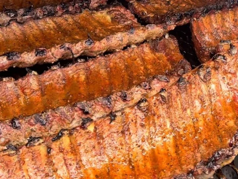 Close-up of grilled salmon fillets with a caramelized, crispy surface and grill marks.