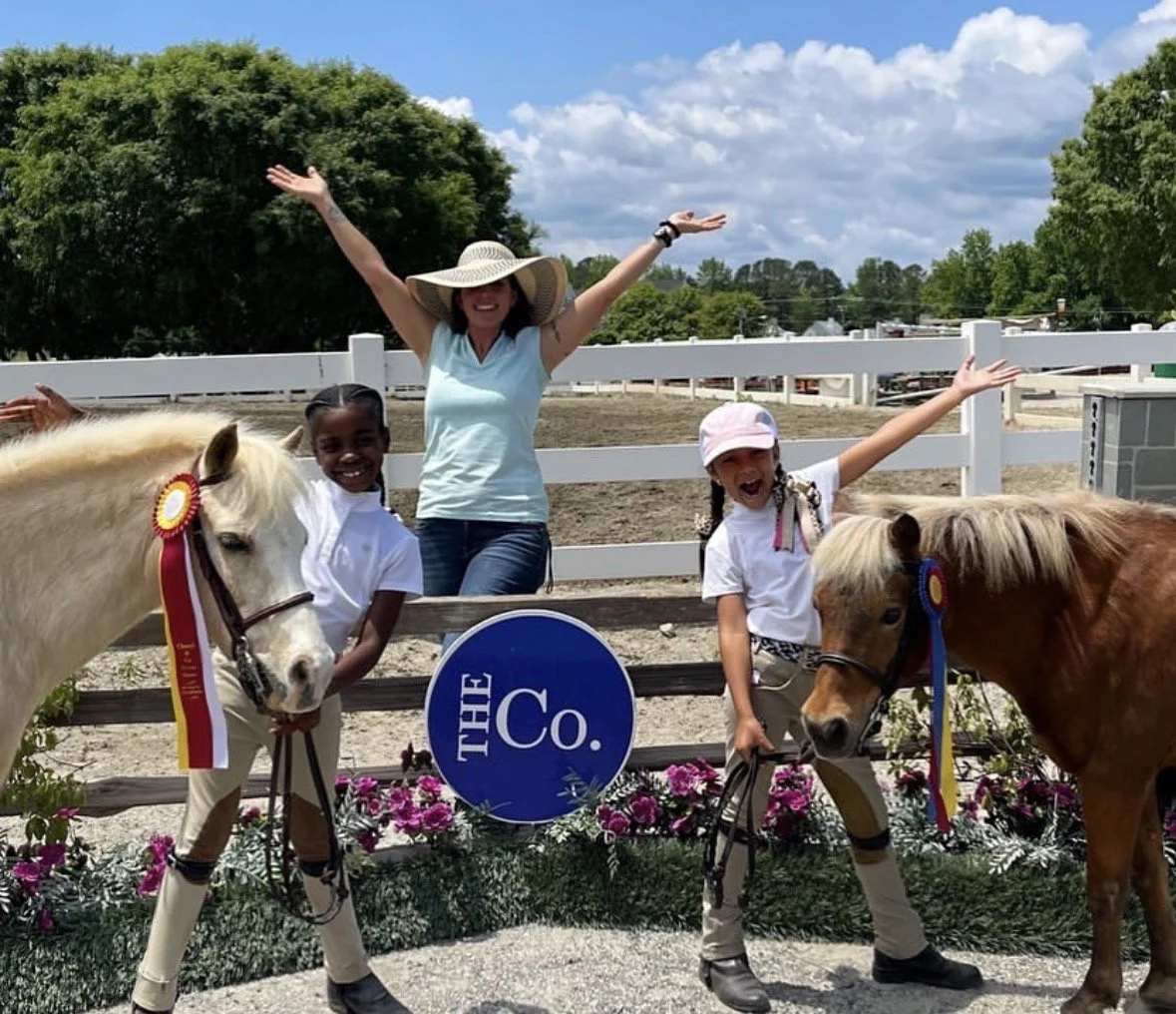 Maureen Myers stands with show ponies and showing riders with champion  ribbons ate
