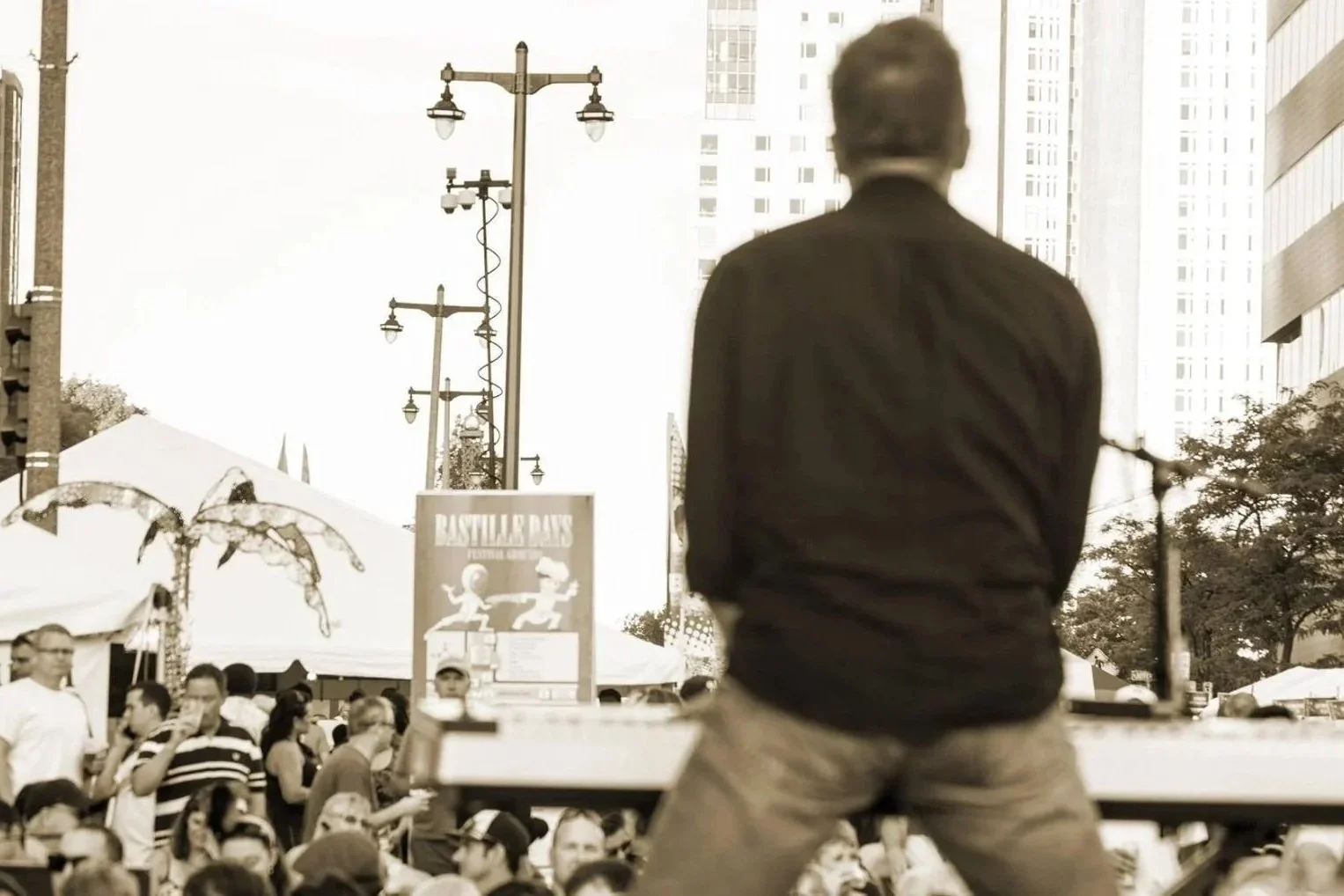 Matt playing guitar in front of a city crowd