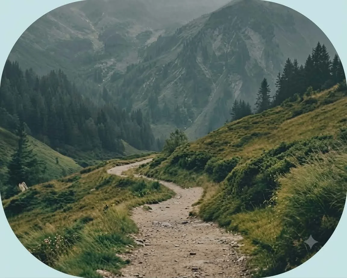 Chemin de terre serpentant à travers une vallée verdoyante entourée de montagnes et de forêts.