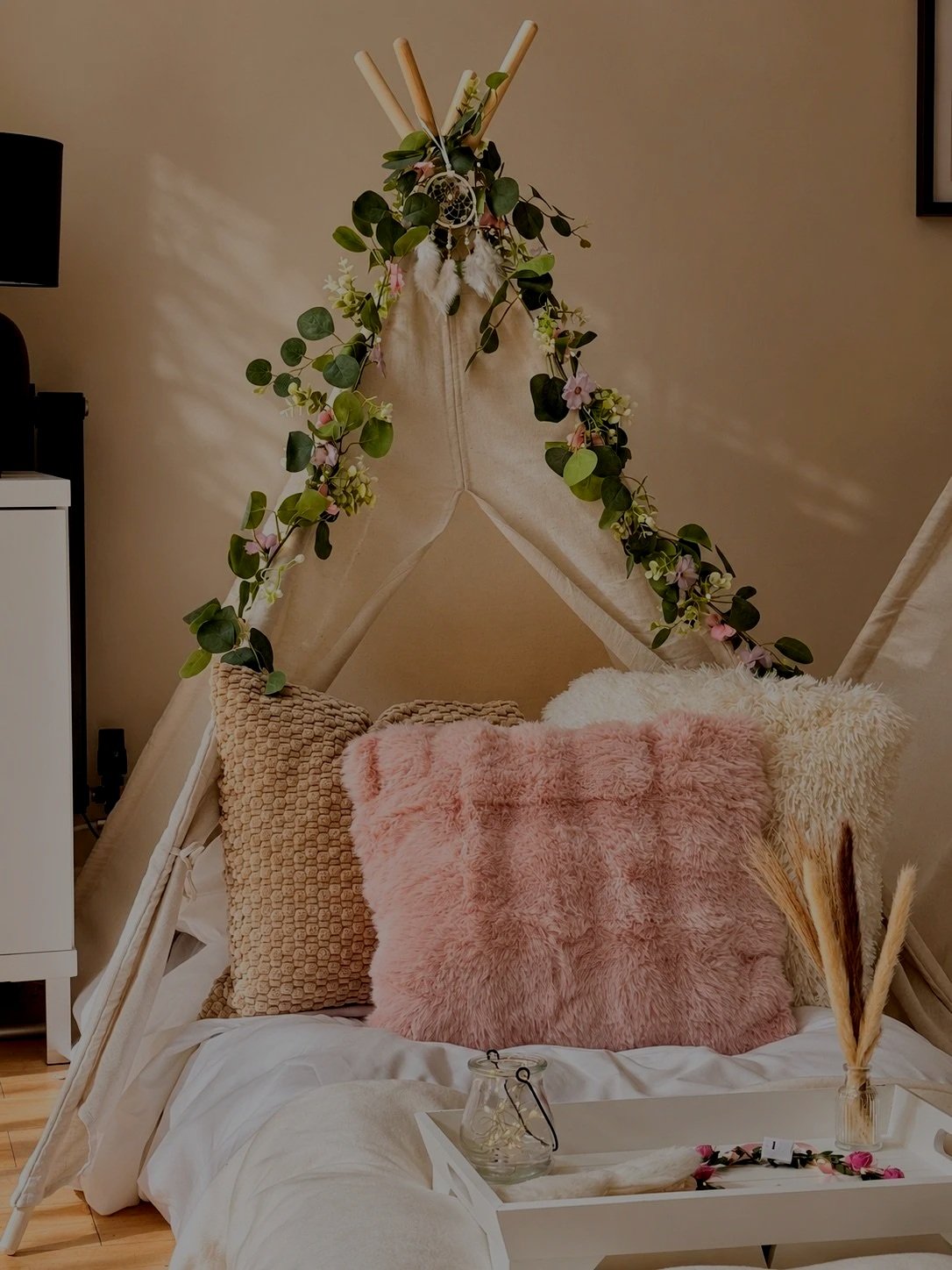 Boho Chic teepee sleepover party by Sweet Dreams Events showing cream teepees with eucalyptus garlands, dream catchers, fluffy cushions in cream and gold tones, styled breakfast trays with floral crowns and fairy lights for a girls birthday party