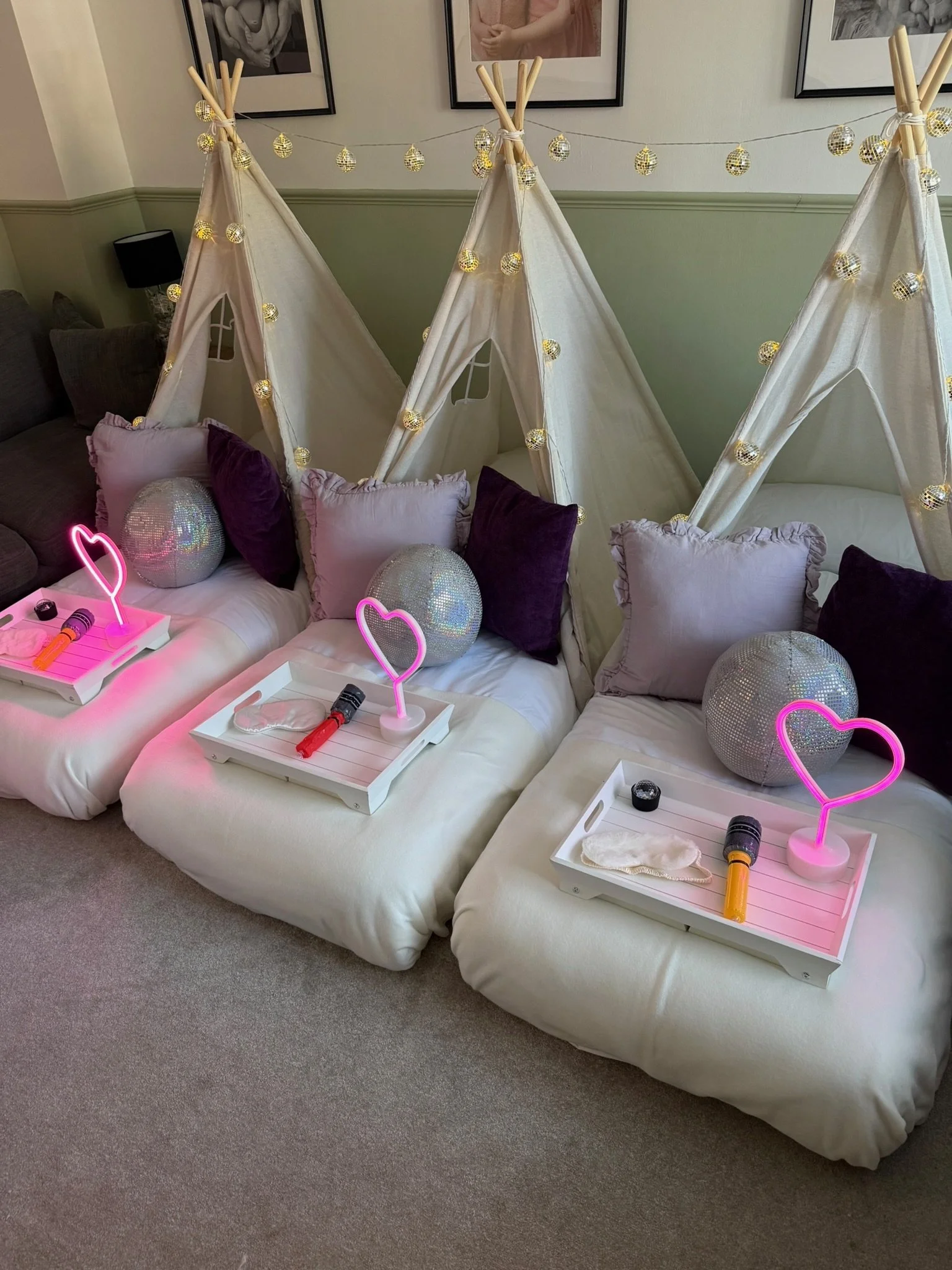 Glitterball Disco teepee sleepover party for three children in Surrey, styled with disco ball fairy lights, pink neon heart lamps, sequin cushions and breakfast trays by Sweet Dreams Events.
