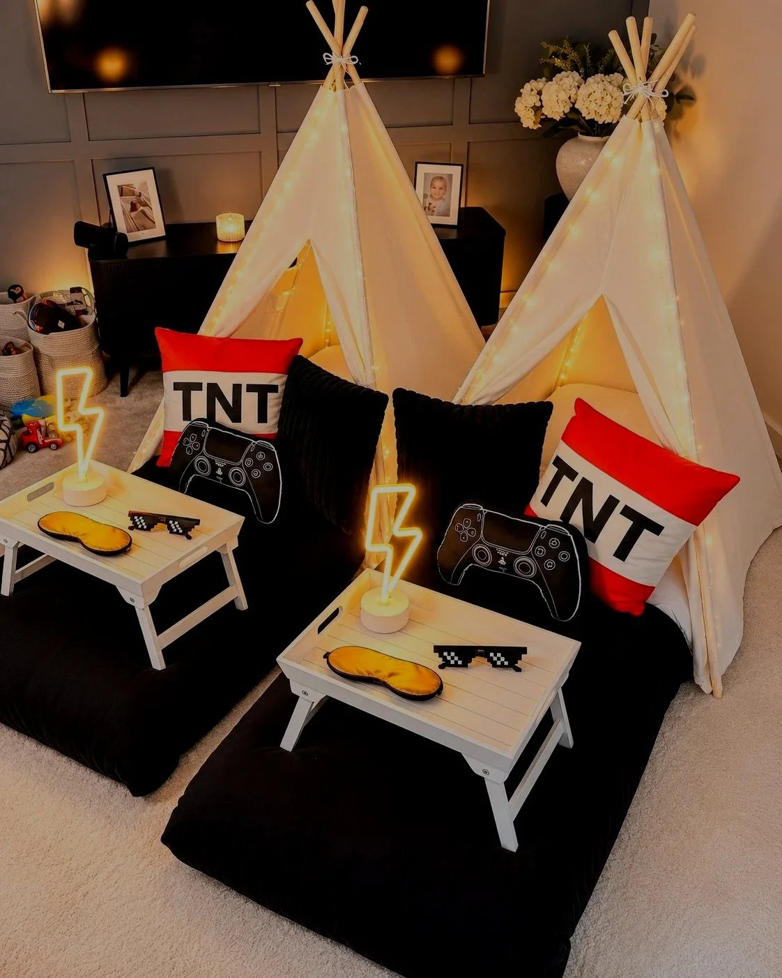 Level up themed sleepover teepee setup with TNT cushion, pixel sunglasses and PlayStation controller pillows for a children's party in Surrey