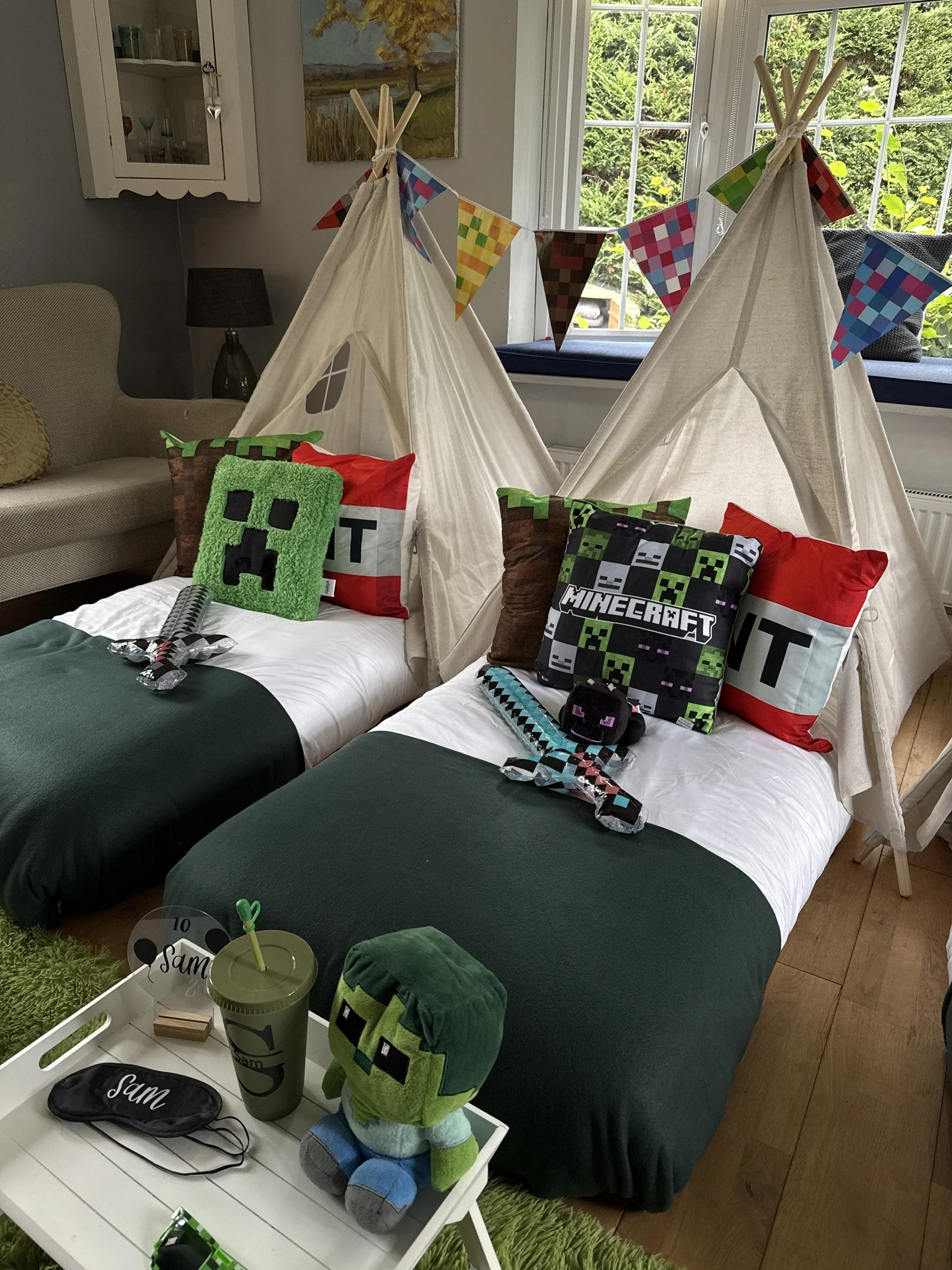 Minecraft teepee sleepover party with two beds, Creeper and TNT cushions, foam swords and a personalised tray, styled by Sweet Dreams Events in Surrey