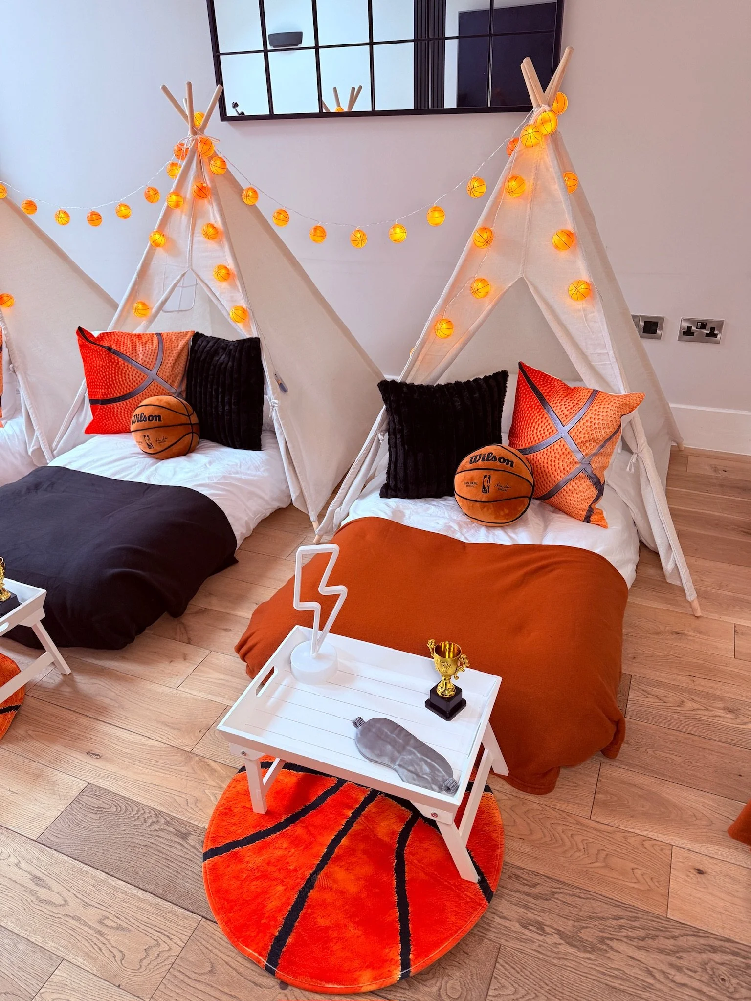 Basketball teepee sleepover party hire in Surrey showing multiple setups with neon lightning bolts, basketball rugs and trophies