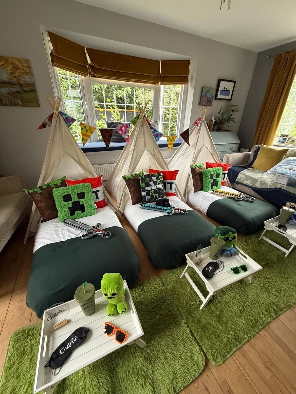 Minecraft teepee sleepover party for three children with Creeper cushions, foam swords, pixel sunglasses and personalised trays, styled by Sweet Dreams Events in Sussex