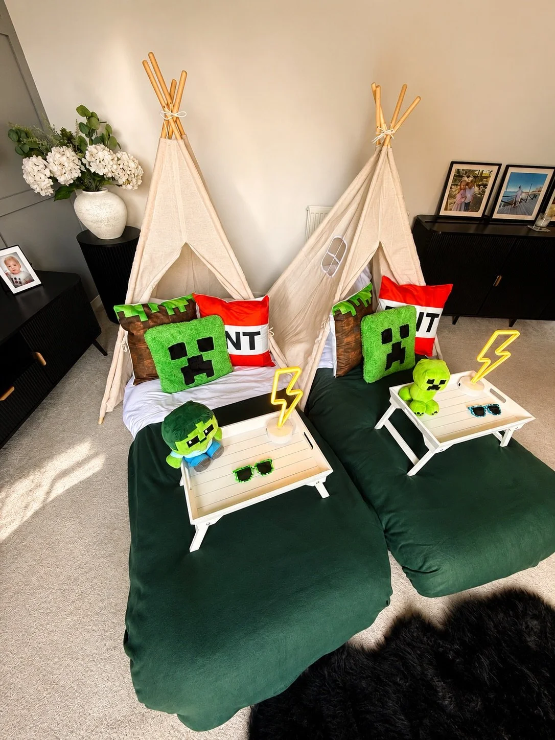Minecraft Sleepover teepee party by Sweet Dreams Events showing two cream teepees with glowing lightning bolt neon lamps, Creeper face cushions, Minecraft plushies and dark green bedding for a boys birthday party in Surrey