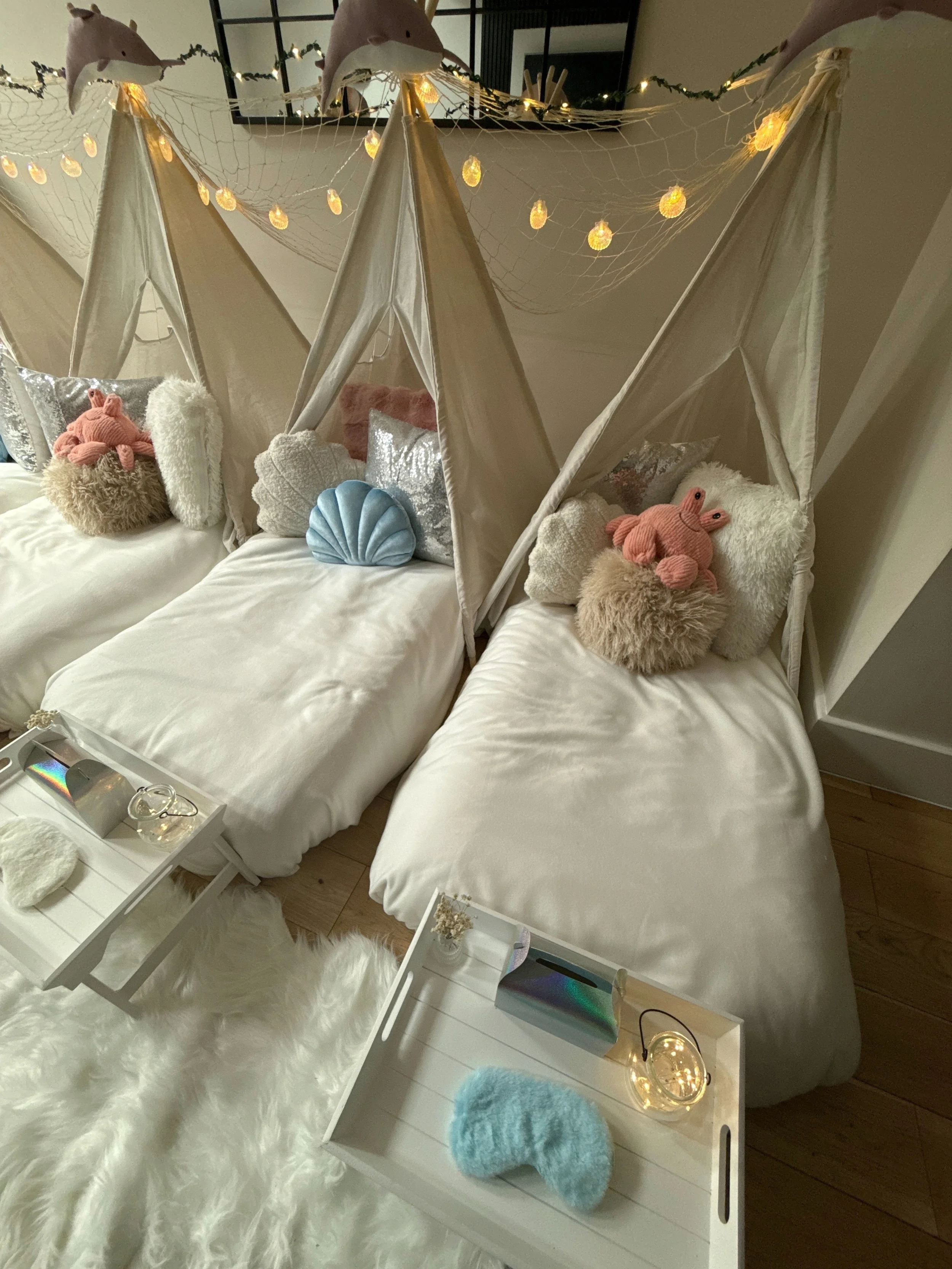 Mermaid Lagoon themed sleepover party with three teepees, fairy light jars, and ocean blue shell cushions in Surrey
