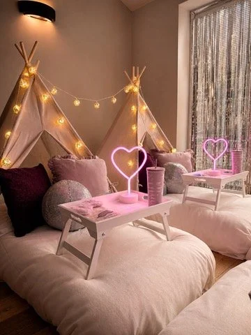 Pink themed teepee sleepover party in Surrey with heart neon lights, sequin cushions and personalised trays by Sweet Dreams Events