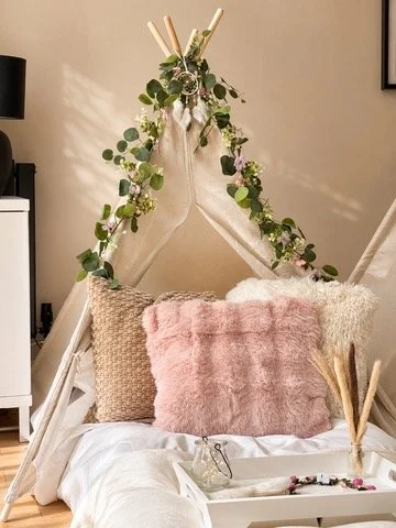 Boho Chic teepee sleepover party in Surrey with eucalyptus garland, pink faux fur cushion and neutral styling by Sweet Dreams Events