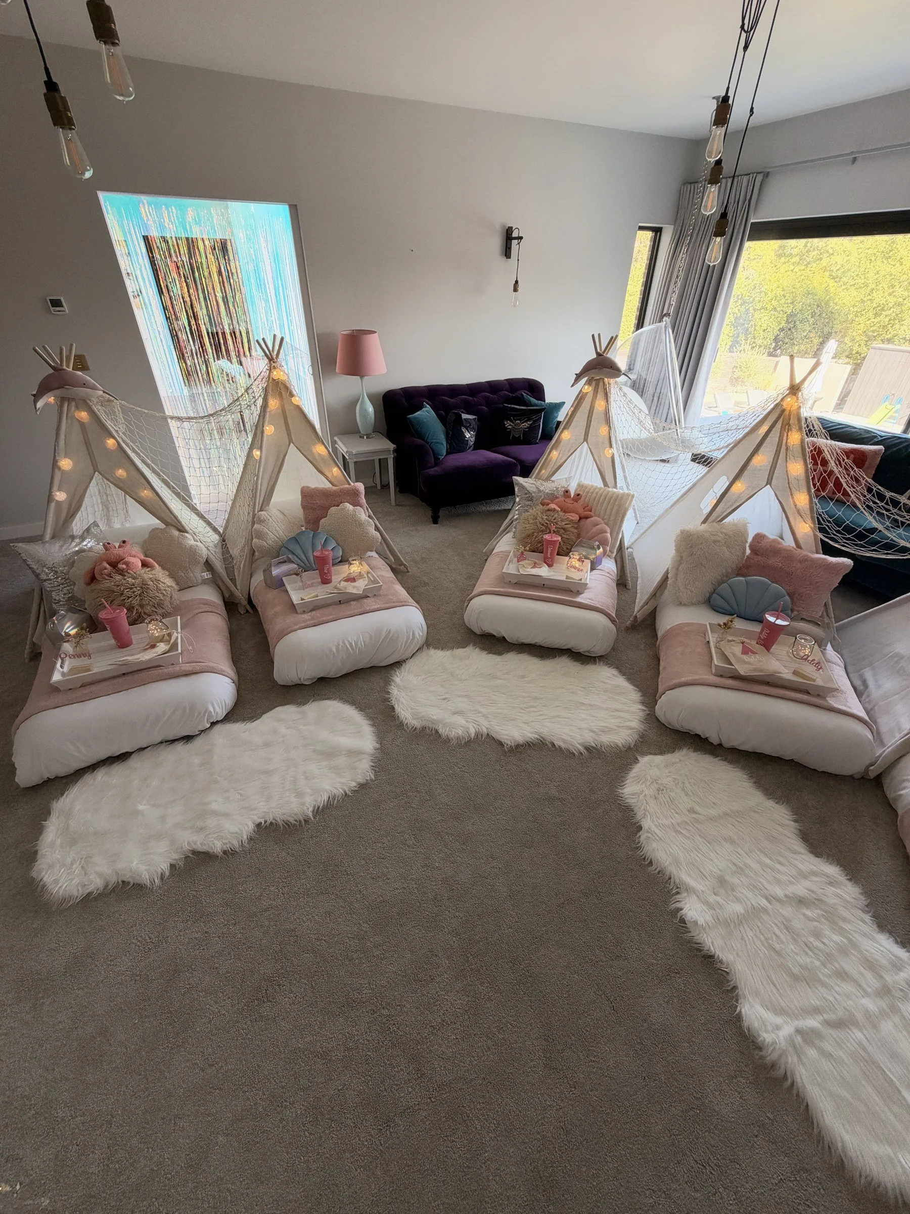 Four teepee mermaid sleepover party set up in a Esher living room with shell lights and styled breakfast trays