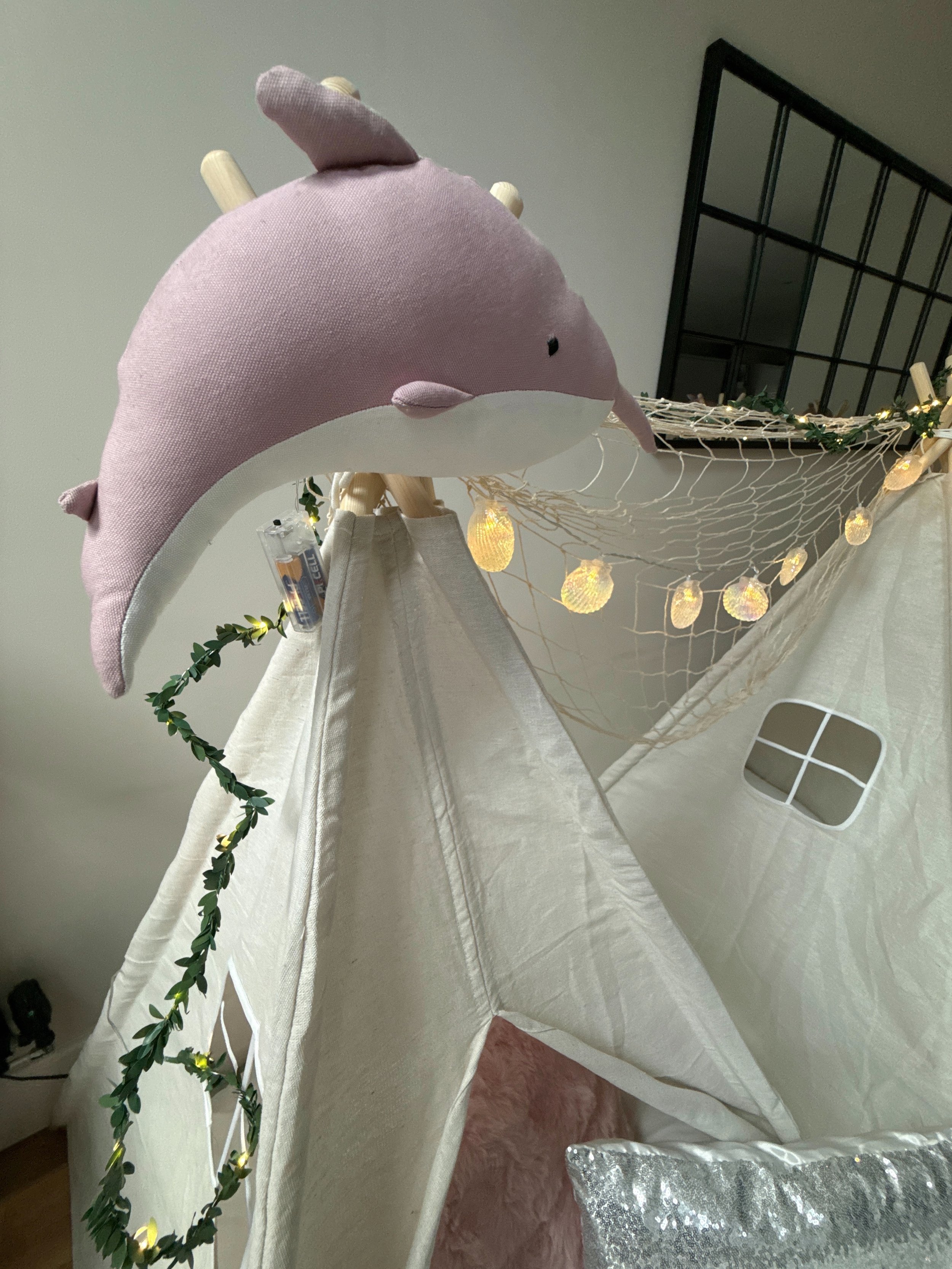 Pink narwhal plushie on top of Mermaid Lagoon teepee with shell fairy lights and eucalyptus garland in Surrey