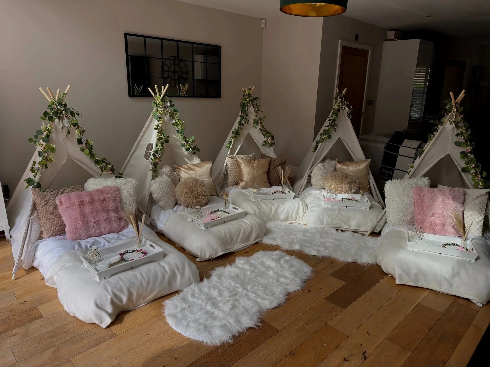 Boho Chic teepee sleepover party by Sweet Dreams Events showing cream teepees with eucalyptus garlands, dream catchers, fluffy cushions in cream and gold tones, styled breakfast trays with floral crowns and fairy lights for a girls birthday party